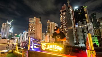 Une vue nocturne d’une ville, avec des bâtiments illuminés et une enseigne pour le whisky irlandais Jameson.