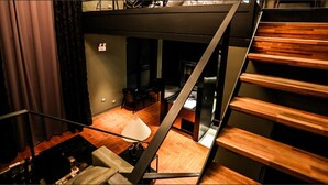 A modern interior with a staircase, a dining area, and a visible bed. - Amare Hotel Jakjeon (Incheon)