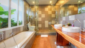 A modern bathroom with a glass-enclosed shower, a large bathtub, and a wooden vanity with two sinks. - Villa Umah Putih (Canggu)