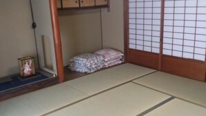 Ein traditioneller japanischer Raum mit Tatami-Boden, Shoji-Schirm und einem kleinen Schrein.
