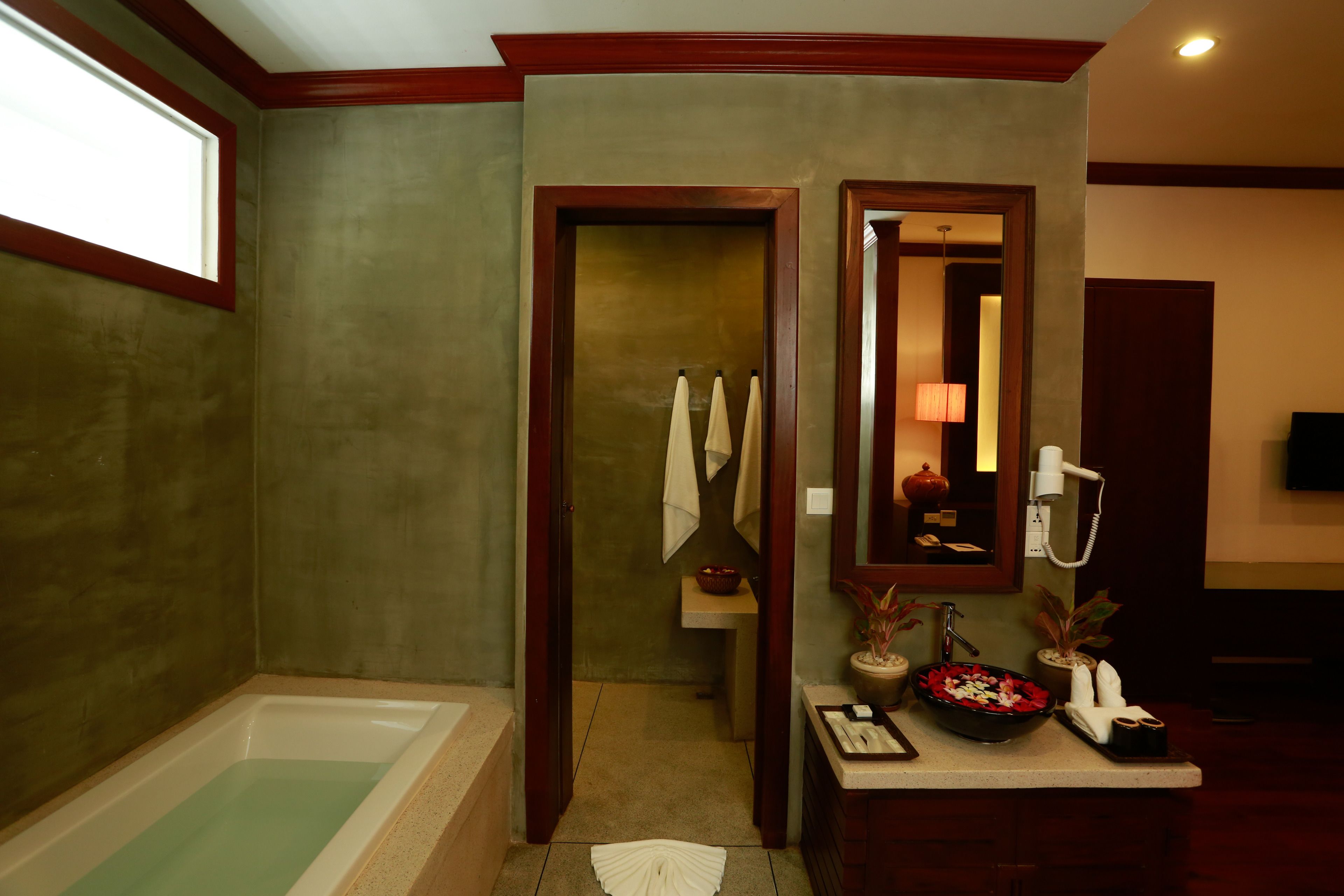 king suite with balcony, garden and pool view | bathroom | designer toiletries, hair dryer, bathrobes, slippers