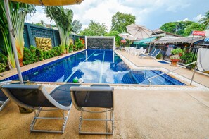 Una piscina al aire libre, camas de piscina gratis, sombrillas