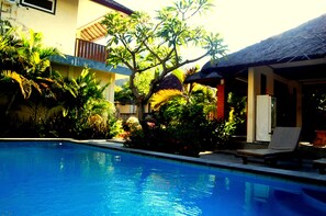 Una piscina al aire libre, tumbonas