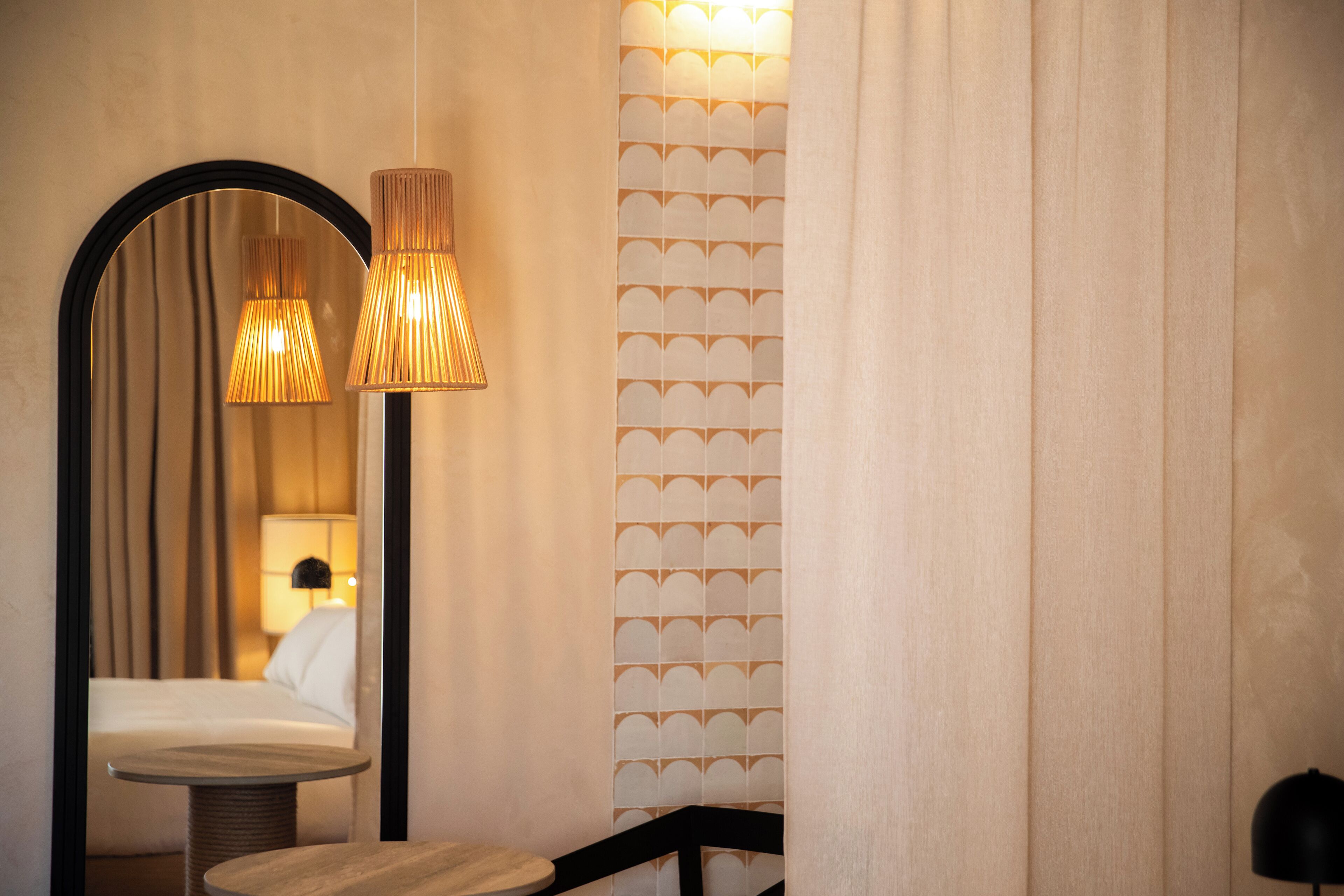 Ein Zimmer mit einem runden Tisch, einem Spiegel und zwei Lampen.