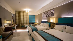 Een hotelkamer met twee bedden, een bureau, een stoel en een televisie.