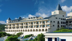 Een groot, meerhoog hotel met een opvallende klokkentoren, meerdere balkons en een reeks boogvensters.