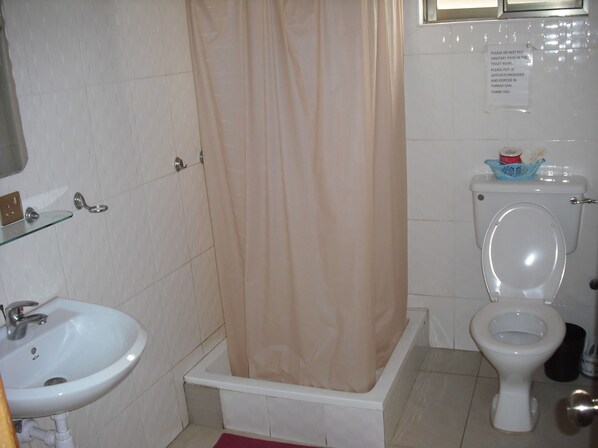 Un baño con lavamanos blanco, bañera y retrete.