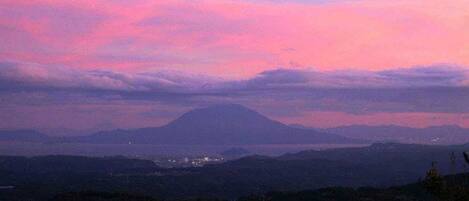 A mountain landscape at dusk with a pink sky.