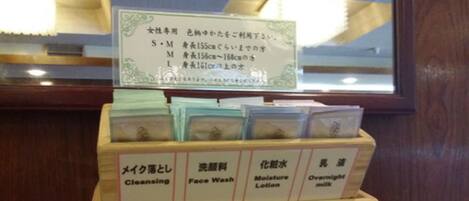 Un expositor de madera con compartimentos identificados para productos de cuidado de la piel, incluyendo limpiador, jabón facial, loción hidratante y leche de noche.