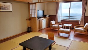 A traditional Japanese-style room with tatami flooring, a low table, and wooden furniture. - Ryokojin Sanso (Kirishima)