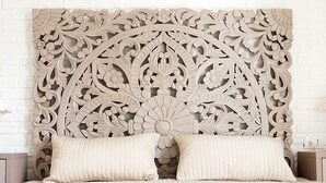 A bed with a carved headboard and two pillows. - Corte San Martino (La Morra)