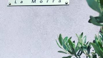 Une enseigne portant le nom « Casa Andrea La Morra » est fixée à un mur.