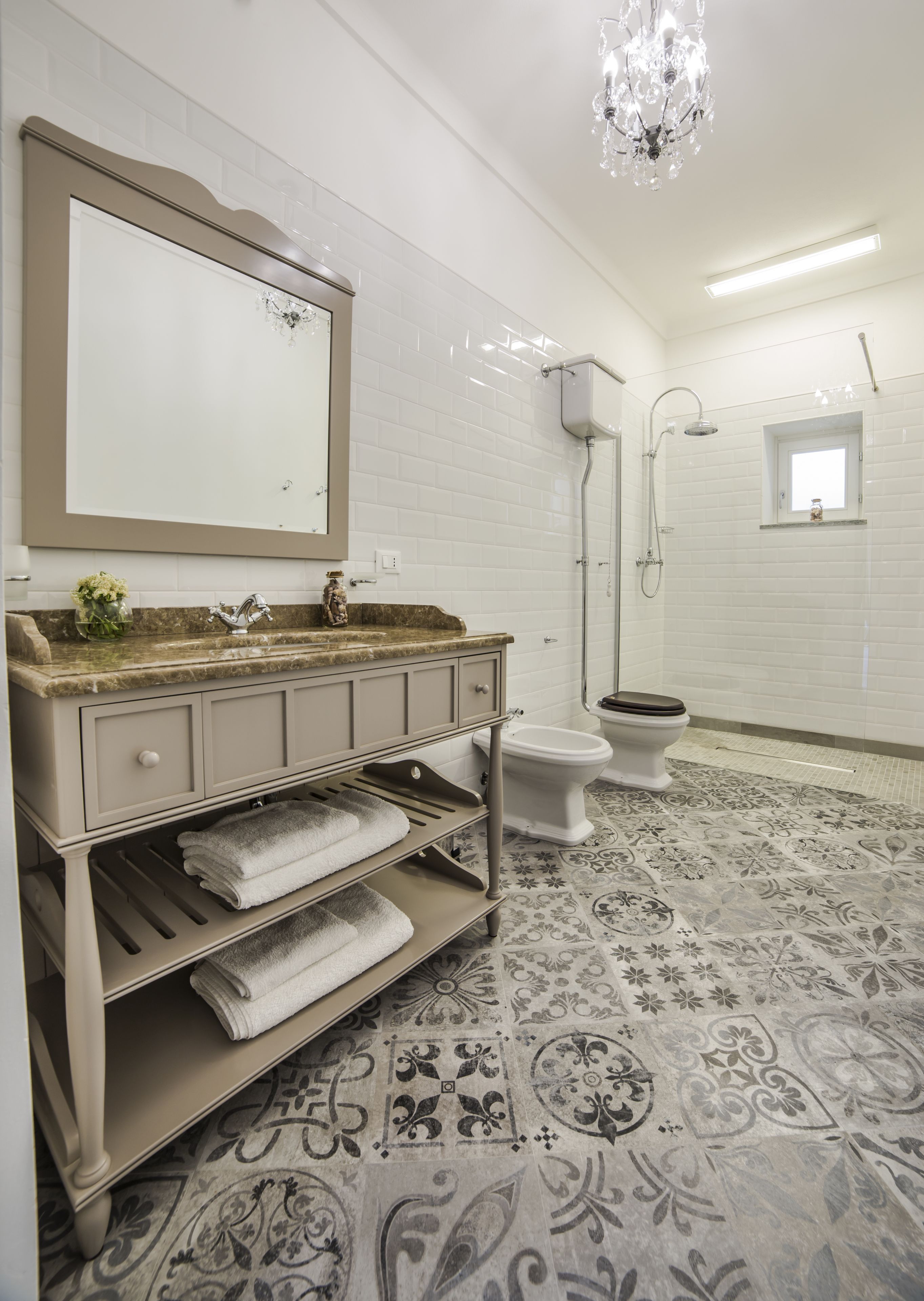 A bathroom with a vanity, sink, mirror, and shower.