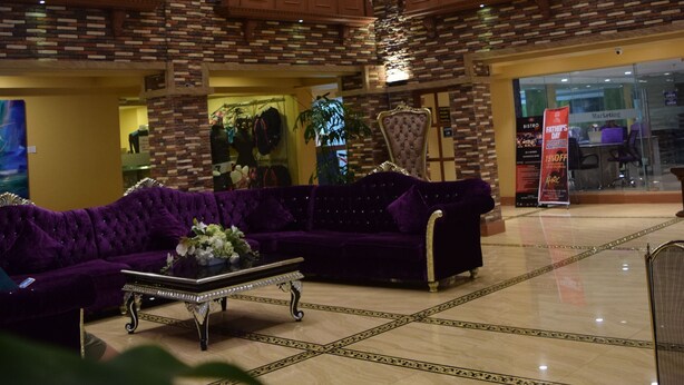 A spacious lobby with a high ceiling, a chandelier, and a purple sofa. - Villa Caceres Hotel (Naga)