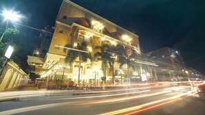 A multi-story hotel with illuminated balconies and a well-lit entrance. - Villa Caceres Hotel (Naga)