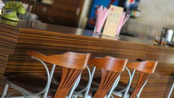 Una zona de bar con mostrador de madera y sillas de metal.