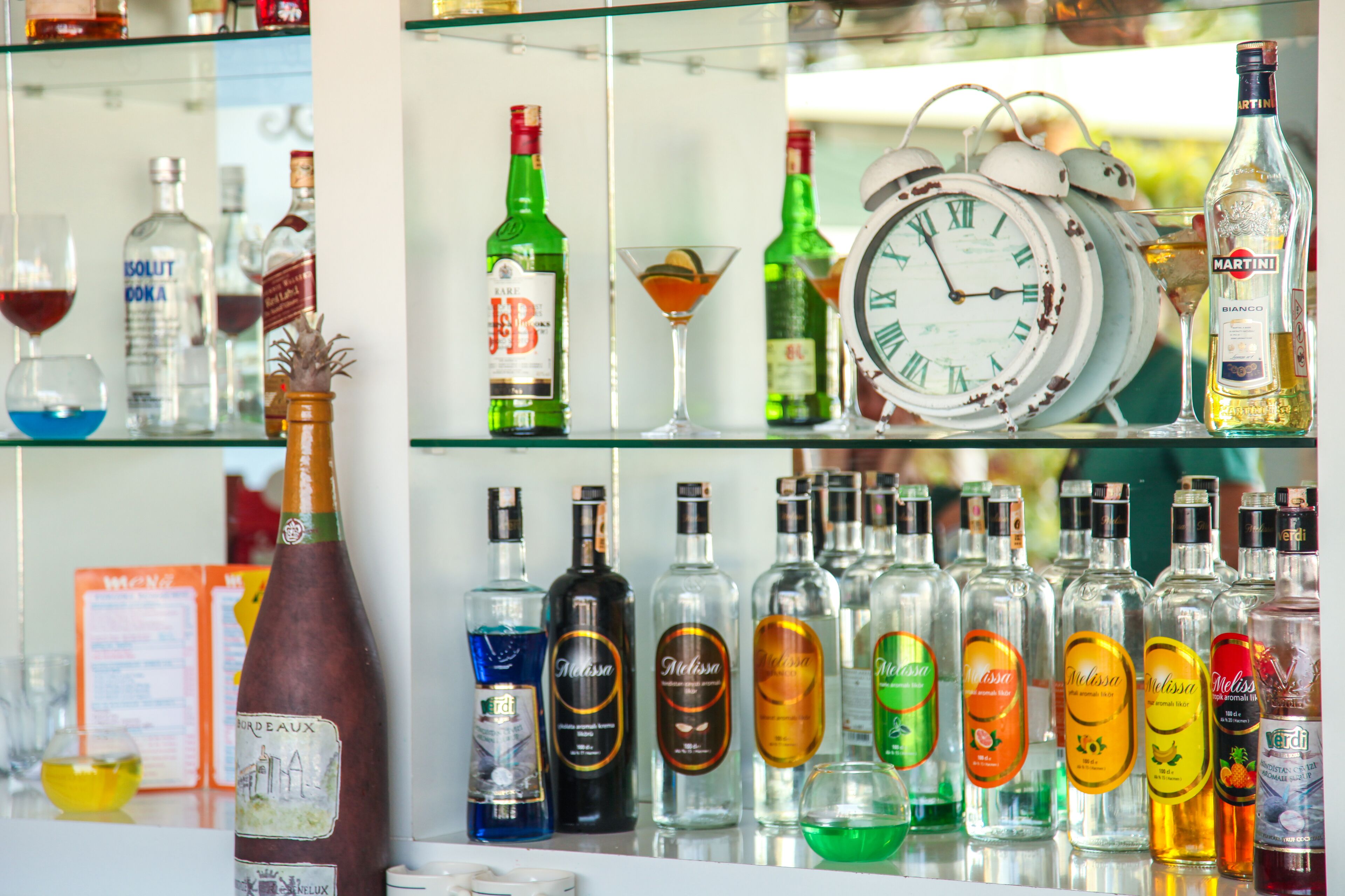 A bar with various liquor bottles and a clock.