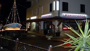 Ein Gebäude mit einem Schild, auf dem „Pizzeria“ und „Ristorante“ stehen, das ein Restaurant kennzeichnet.