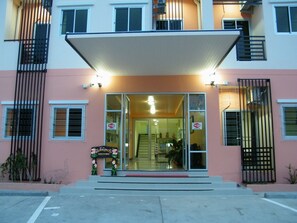 A building with a large entrance, glass doors, and a sign indicating WiFi availability.