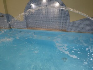 A swimming pool with clear water and a tiled wall. - Residence Villa Marinù (Forio)