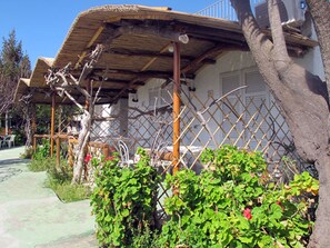 A rustic house with a wooden porch, a lattice fence, and a tree in the foreground. - Residence Villa Marinù (Forio)