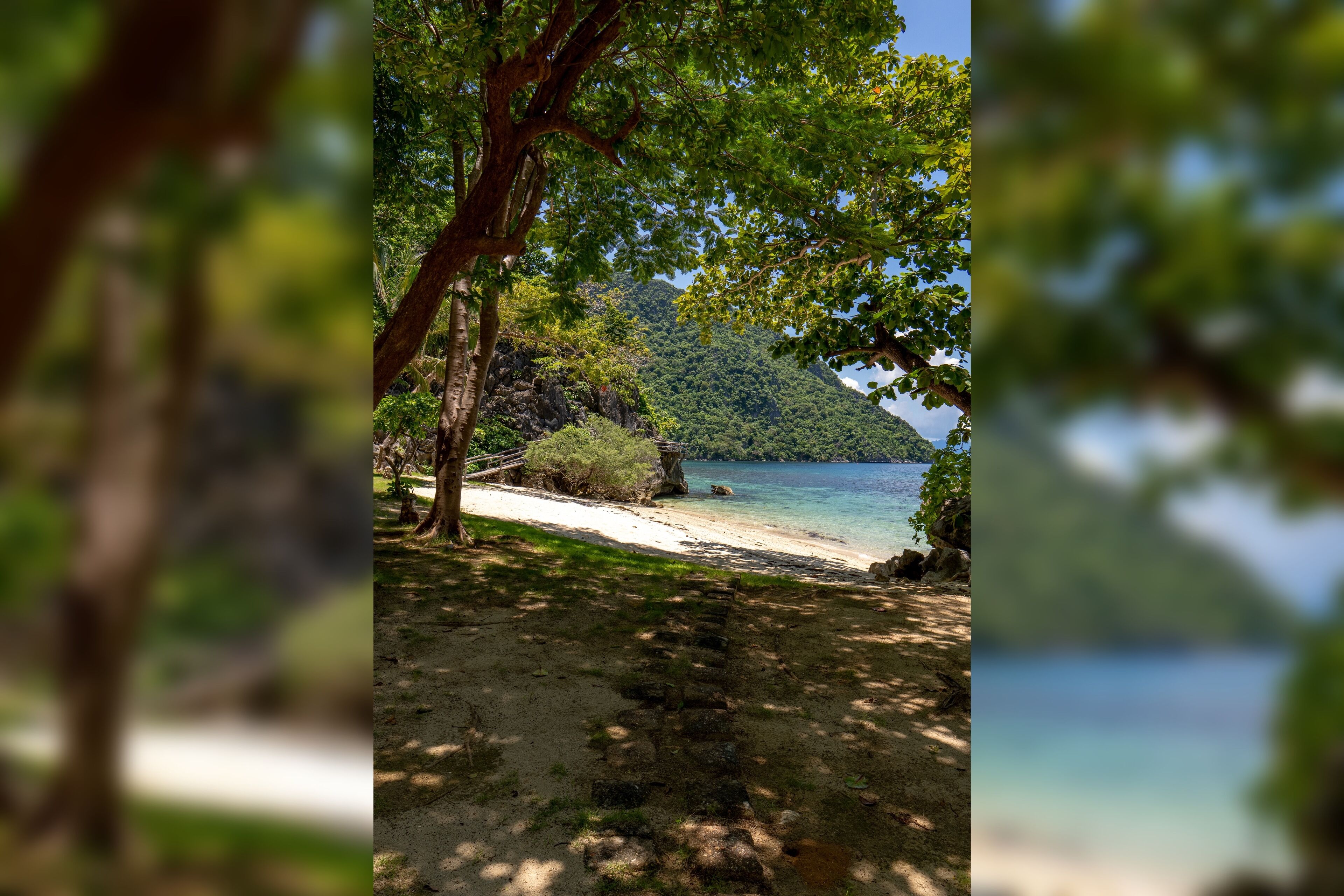 Una playa con vista despejada al agua y un paisaje montañoso al fondo.