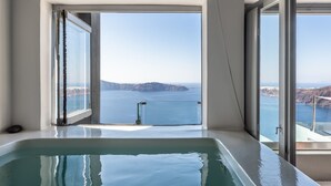 Una habitación moderna con un ventanal grande, una bañera y vistas al mar.