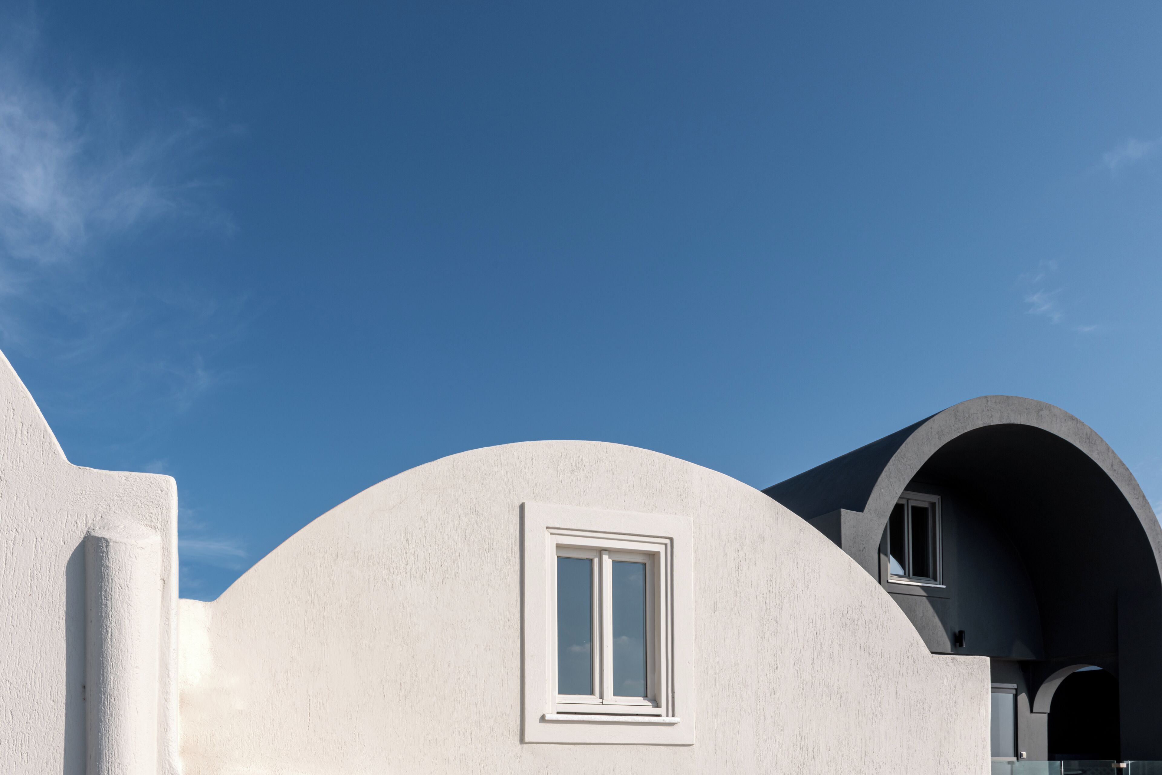 A modern building with a curved facade and a window.