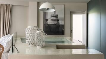 A modern hotel room with a large window, a painting of a boat, a white lamp, and a small pool area.