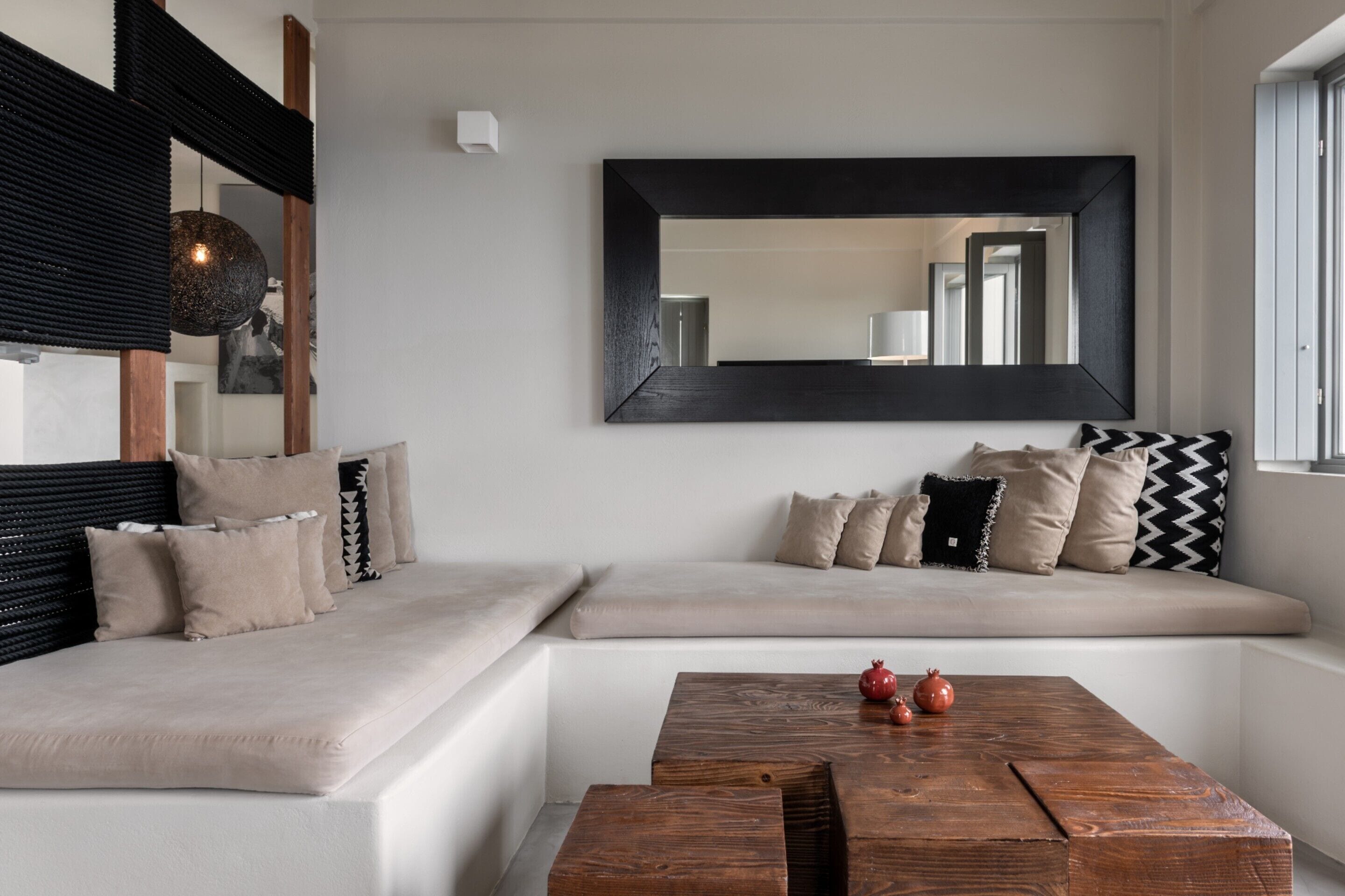 A modern living room with a sofa, a coffee table, and a large mirror.