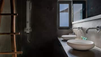 Un baño moderno con una escalera de madera, una cabina de ducha de vidrio y dos lavamanos.
