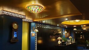 A reception area with a clock, decorative lamps, and a sign that reads "SAPA HOUSE". - Sapa House Hotel Halal Certified (Sa Pa)