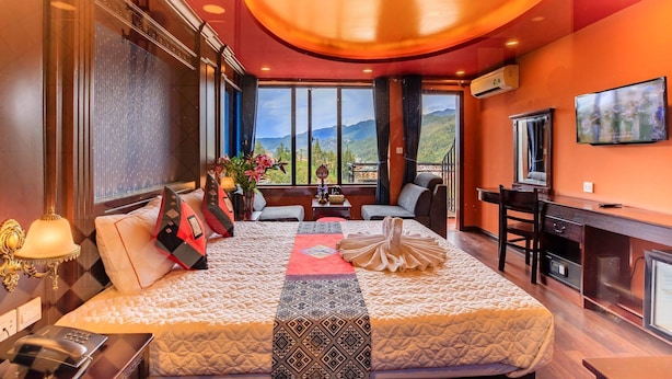 A hotel room with a large bed, a desk, and a TV. - Sapa House Hotel Halal Certified (Sa Pa)