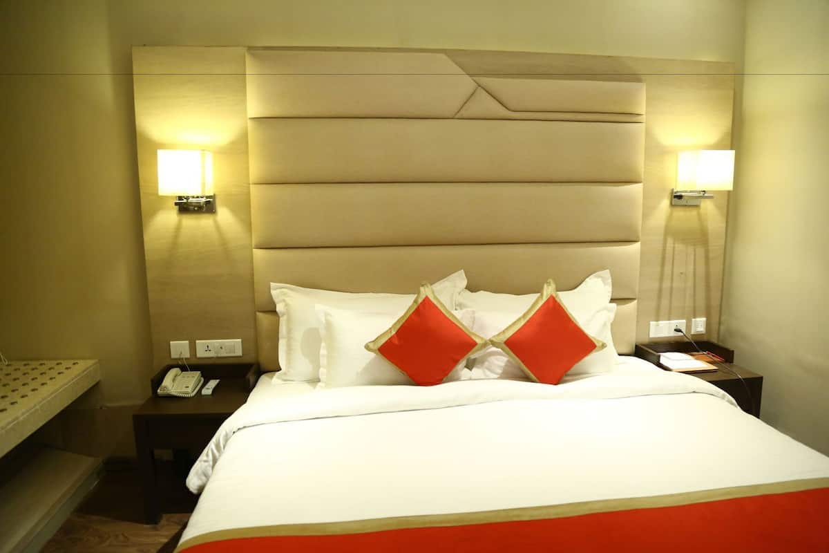 A hotel room with a bed, bedside lamps, a phone, and a nightstand.