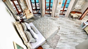 Ein geräumiges Schlafzimmer mit einem großen Bett, mehreren Fenstern und Meerblick.
