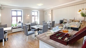 A modern dining area with a buffet setup, including a variety of food items and a beverage station. - Apartamenty Centrum Villa Perla (Jelenia Gora)