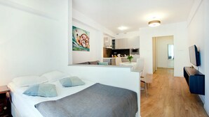A modern hotel room with a bed, bedside table, lamp, and a painting on the wall. - Apartamenty Centrum Villa Perla (Jelenia Gora)