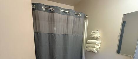 A compact bathroom with a toilet, sink, and a shower curtain.