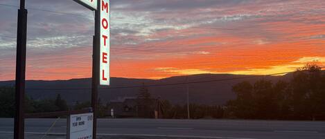 A motel sign with "Kelly's View" and "Motel" written on it, a sign indicating "Open Year Round" and "Vacancy", and a road in the foreground.