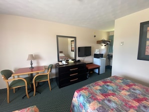 Relax in a cozy space with a comfortable bed, desk, and TV.