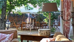 Een terras met een tafel, stoelen en een lamp.