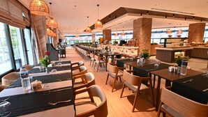 A spacious restaurant with high ceilings, wooden tables and chairs, and hanging pendant lights. - VONRESORT Abant (Bolu)