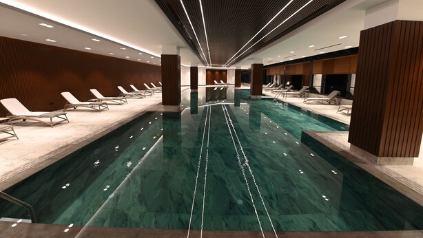 A modern indoor swimming pool with a central lane, lounge chairs along the sides, and a sleek, contemporary design. - VONRESORT Abant (Bolu)