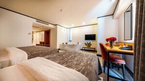 A hotel room with two beds, a desk with a chair, a TV, and a bathroom with a bathtub and shower. - VONRESORT Abant (Bolu)