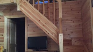 A wooden staircase leading to a loft area with a television on a dresser. - Camping Prado Verde (Vilamos)