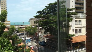 A view from a window overlooking a street with buildings, trees, and parked cars. - Hotel Italia Meireles (Fortaleza)