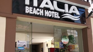 The exterior of Italia Beach Hotel with a glass entrance, a Christmas tree inside, and a staircase leading to the entrance. - Hotel Italia Meireles (Fortaleza)