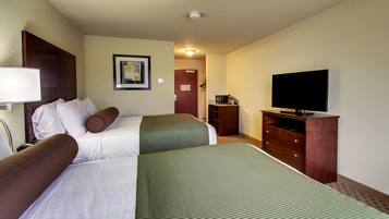 A hotel room with two beds, a television, a dresser, and a framed picture on the wall.