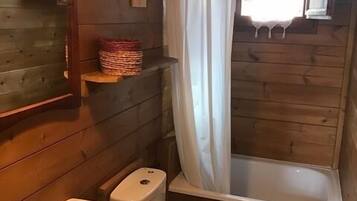 A wooden cabin bathroom with a sink, toilet, and bathtub.