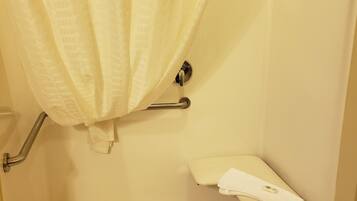 A shower area with a glass door, a towel rack, and a shower control panel.